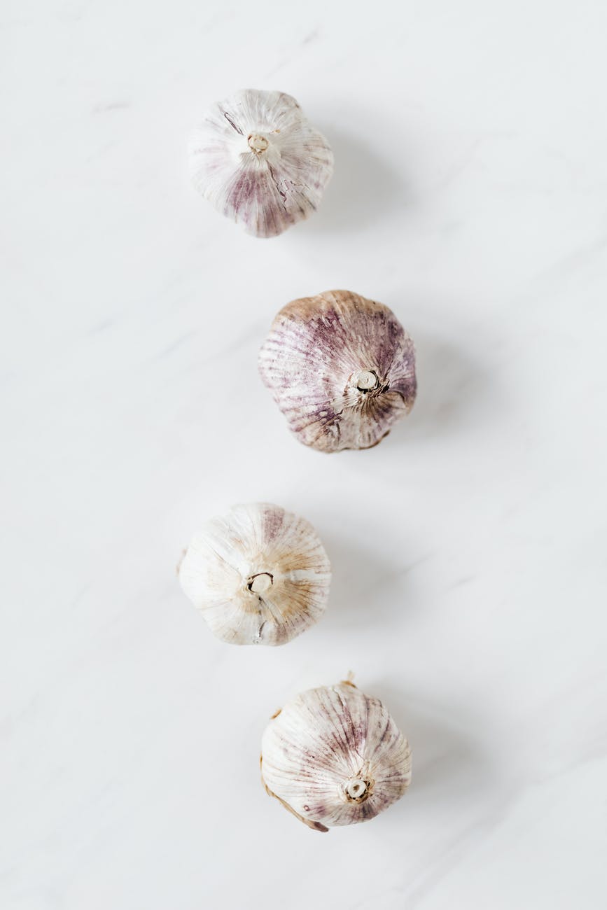 raw garlic on white marble table